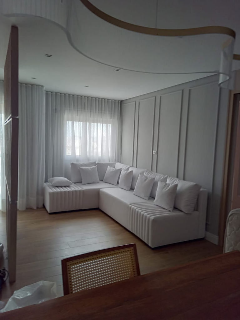 Cortinas brancas em sala com sofá de canto