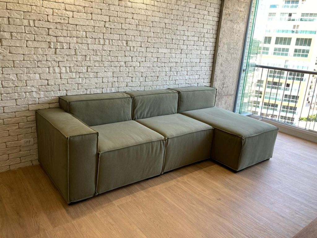 Sofá verde com chaise em varanda